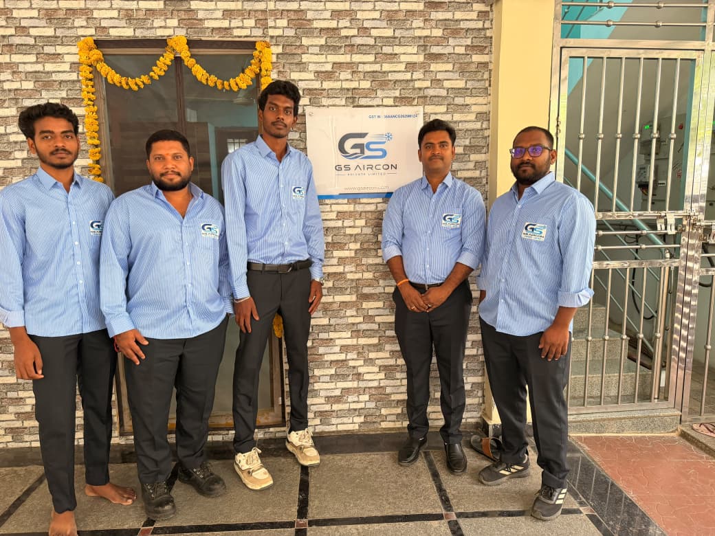 The GS Aircon service team outside the company office beneath the GS Aircon signboard